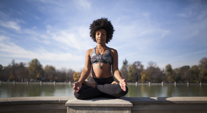 Woman practicing yoga in cross-legged seated pose to reduce stress