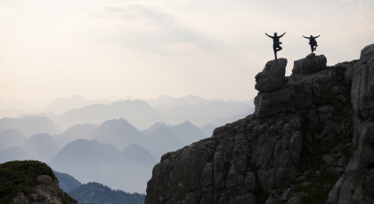 People practicing tree pose (vriksasana) at scenic mountain top