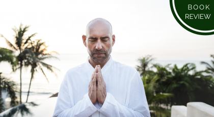 Senior man practicing yoga outside looking tranquil in namaste pose
