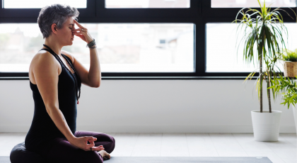 Mature woman practicing yogic breathing for better sleep
