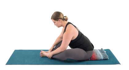 Woman practicing bound angle yoga pose to relieve high blood pressure
