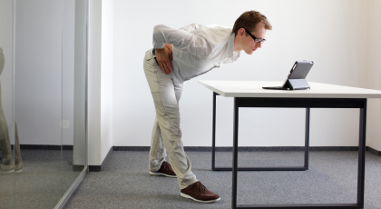 Man performing easy yoga back stretch in workplace