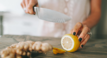  Yoga teacher cutting lemon and ginger to improve her digestion