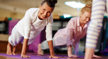 Older beginner yoga students practicing yoga for stress and the brain in Plank Pose (Phalakasana)