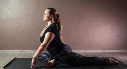Woman practicing yoga for back pain Pigeon Pose (Kapotasana)