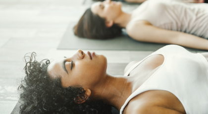 Women practicing yoga savasana 