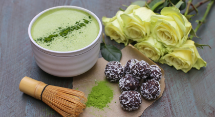 composition of a cup of matcha, healthy snacks and roses