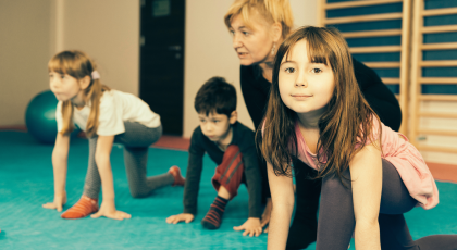 Yoga class with children doing sun salutations