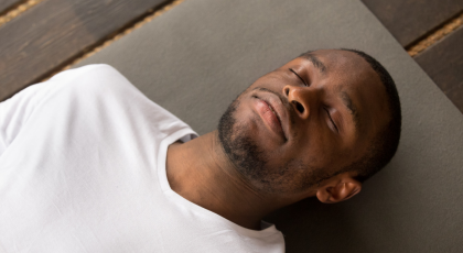 Yoga man lying down in savasana 