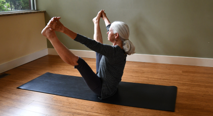 woman practicing yoga upward facing wide leg forward bend