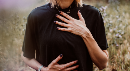 Woman holding her chest and abdomen.