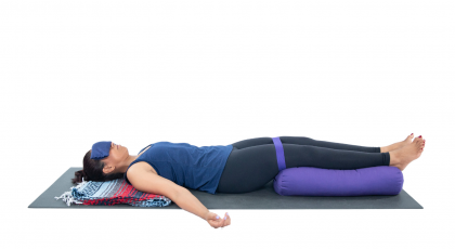 woman practicing restorative yoga svanasana modification with legs bound 