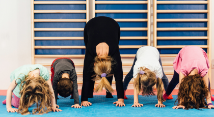 Yoga class with children in Down Dog Pose (Adho Mukha Svanasana)