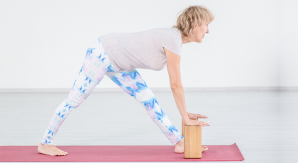 Older yoga woman practicing Intense Side Stretch Pose (Parsvottanasana)