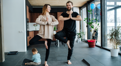 Family practicing yoga in Tree Pose (Vrksasana)