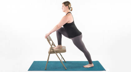 Woman practicing yoga, warrior I with chair 