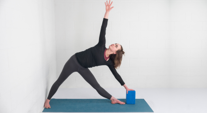 yoga woman practicing triangle pose trikonasana with block