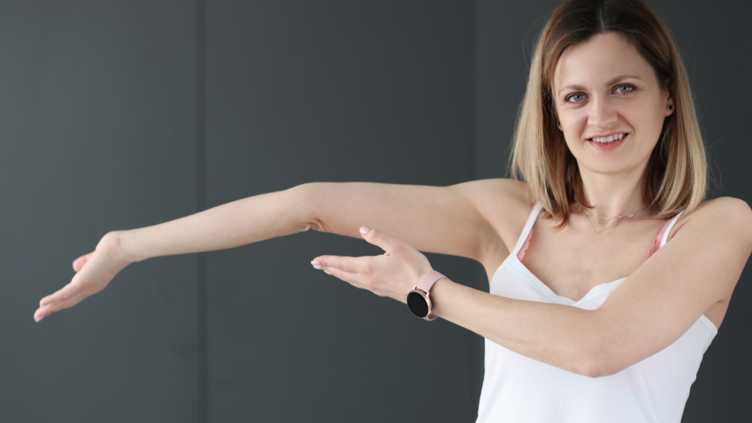 Young smiling woman showing her bent arm. Image depicts Joint Hypermobility elbow joint.