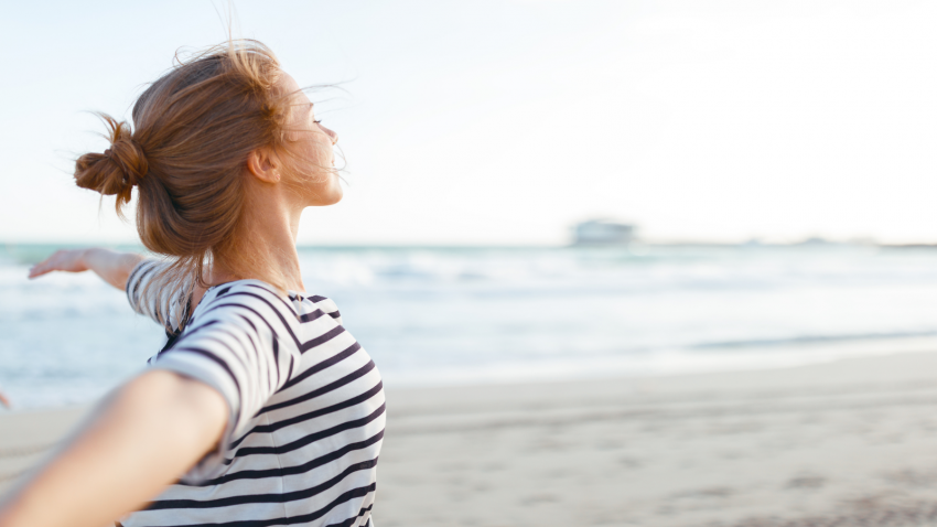 Getting away is one way to replenish the busy yoga teacher happy young woman enjoying freedom with open hands on sea