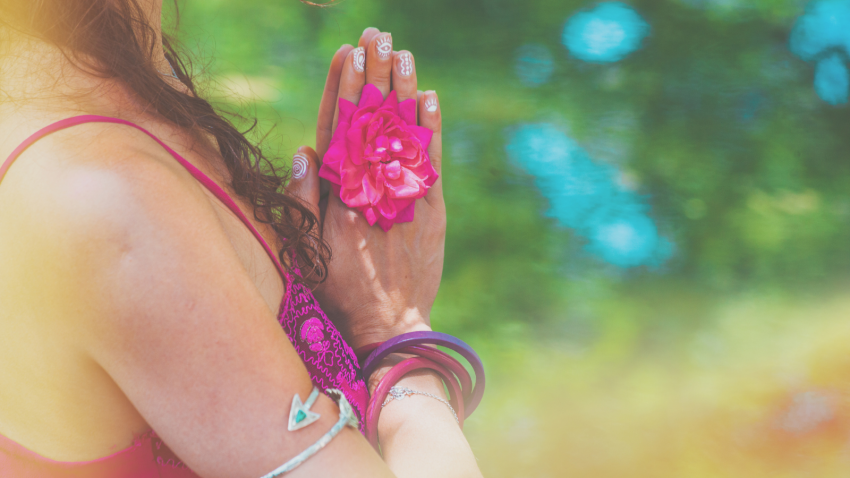 How to practice Anjali Mudra and other Mudras ( like Pushan Mudra) in the study of the Chakras Close up of yoga woman hands in namaste gesture with rose flower outdoor summer day light leak