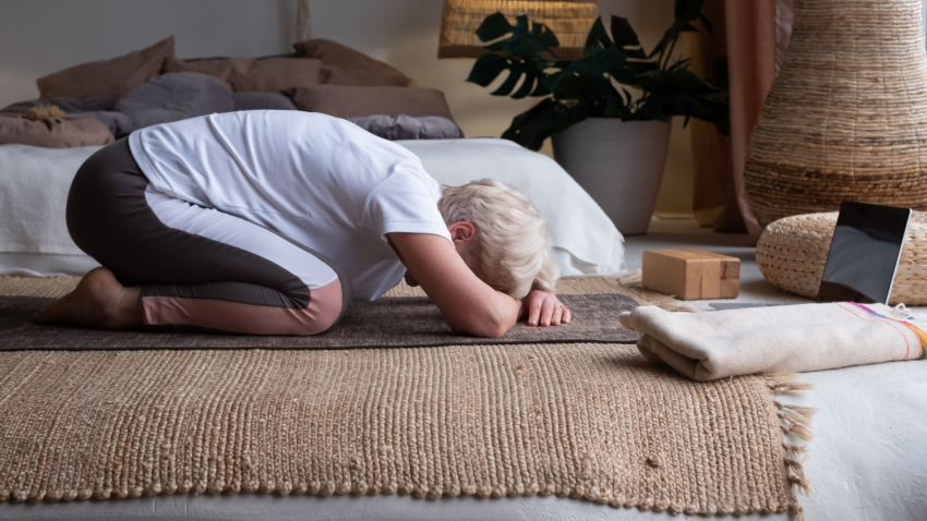  Senior woman doing forward bend yoga exercise Balasana, Child Pose