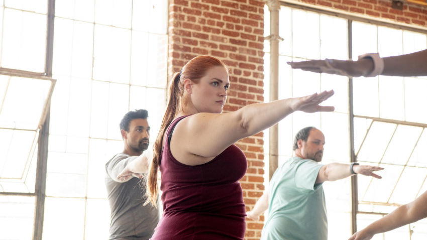 How to practice yoga to reduce anxiety Yoga students in class practicing Warrior II (Virabhadrasana II) to reduce anxiety and stress