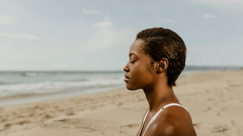 Image depicts the story of realizing that you are enough just the way you are. Black woman meditating on the beach