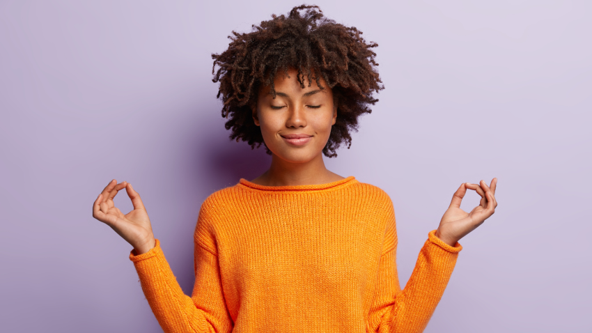 Mudra and gesture. Meditation concept for creating calm and relieving stress. woman in orange clothes meditates indoor, holds hands in mudra gesture