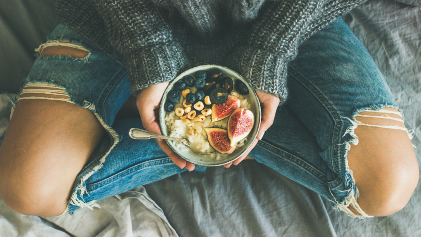 Plant based diet and how to get all your necessary protein and nutrition woman eating healthy plant-based diet with rice coconut porridge with figs, berries, hazelnut