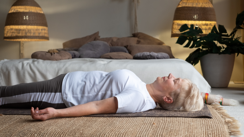 Savasana is synonymous with yoga bliss Senior woman lying on yoga mat practicing Savasana