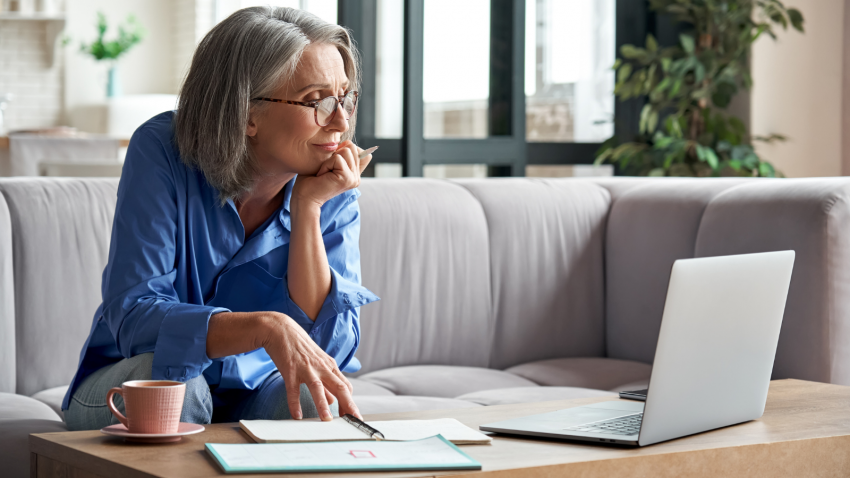 Senior woman continuing to learn which is necessary for brain health older woman taking online webinar on laptop remote working or social distance learning from home