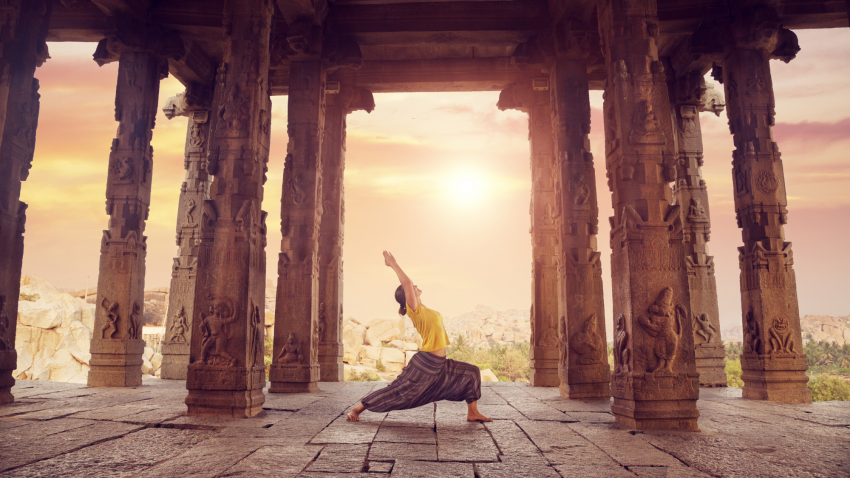 Woman Practicing Warrior 1 in a temple Woman Practicing Warrior 1 in a temple