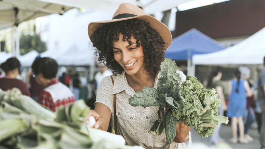 Yoga student buying vegetables at the farmers market.