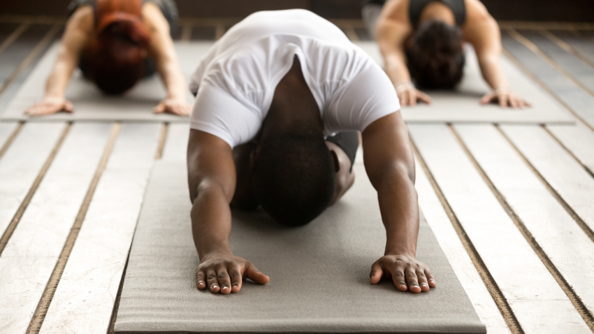 Male yoga student practicing balasana childs pose