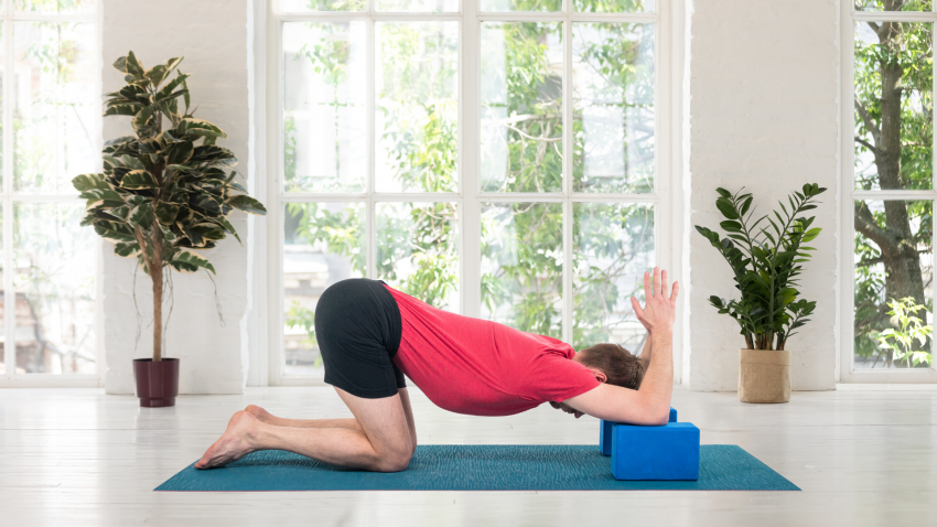Man practicing yoga in Shoulder Opener pose on blocks Man practicing yoga in Shoulder Opener pose on blocks