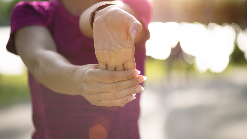 Woman practicing yoga wrist stretch. 