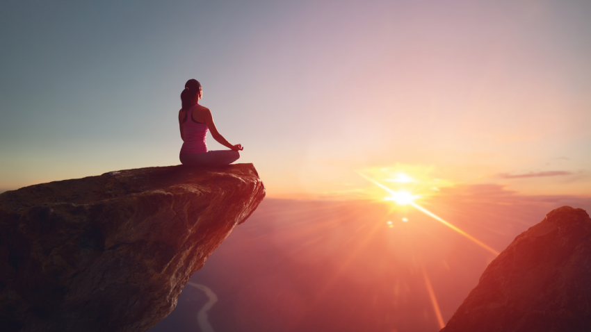 Yoga student practices yoga principles for the new year and meditates on the mountain