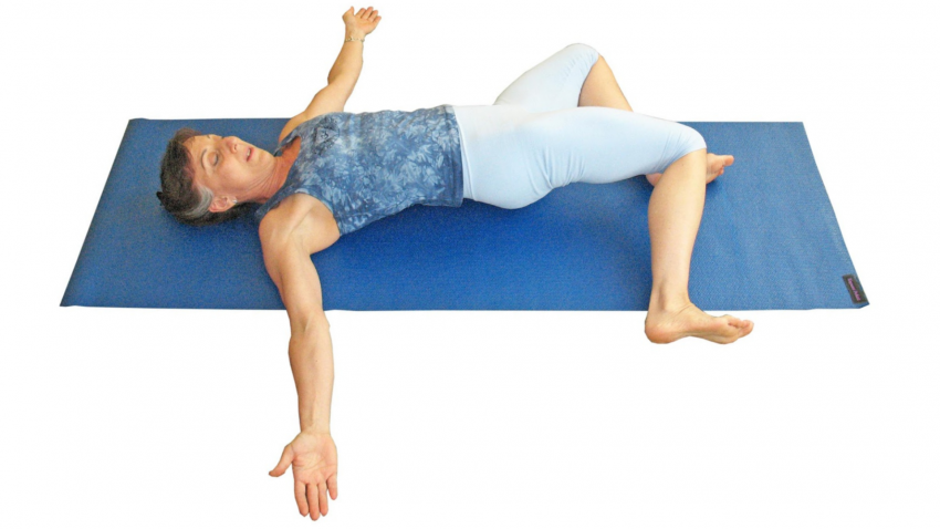 woman practicing supine twist with therapeutic yoga for back pain woman practicing supine twist with therapeutic yoga for back pain