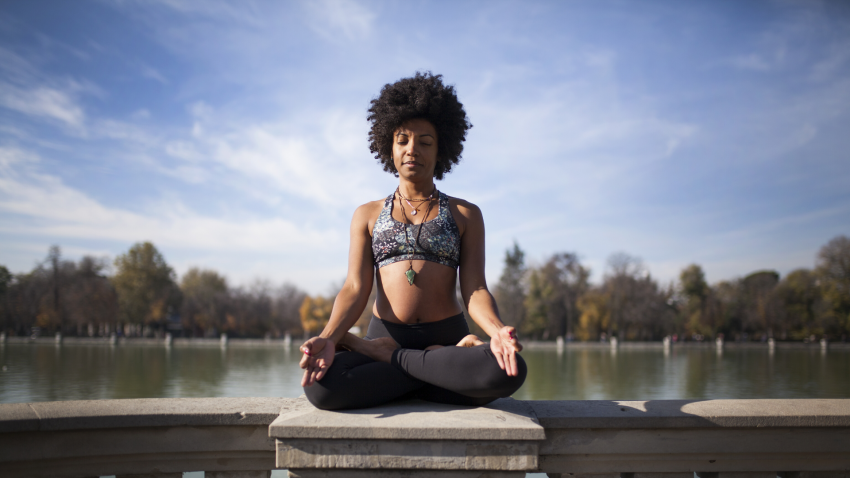 Woman practicing yoga in cross-legged seated pose to reduce stress