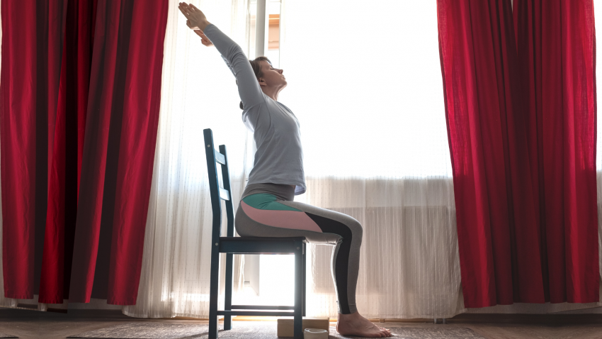 yoga instructor demonstrating chair yoga pose for back health yoga instructor demonstrating chair yoga pose for back health