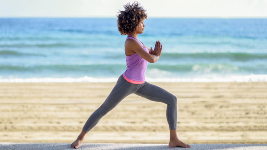 Woman practicing yoga for back pain Warrior I Pose (Virabhadrasana I)