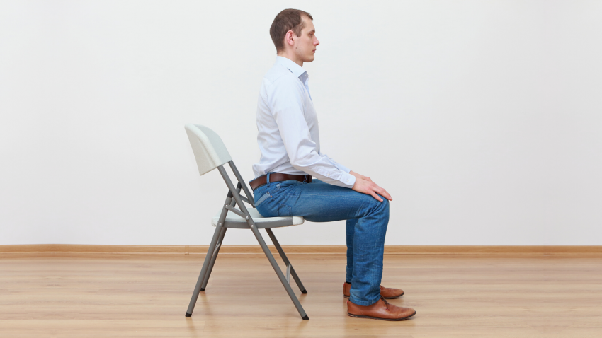 Man practicing yoga pose in a chair Man practicing yoga pose in a chair