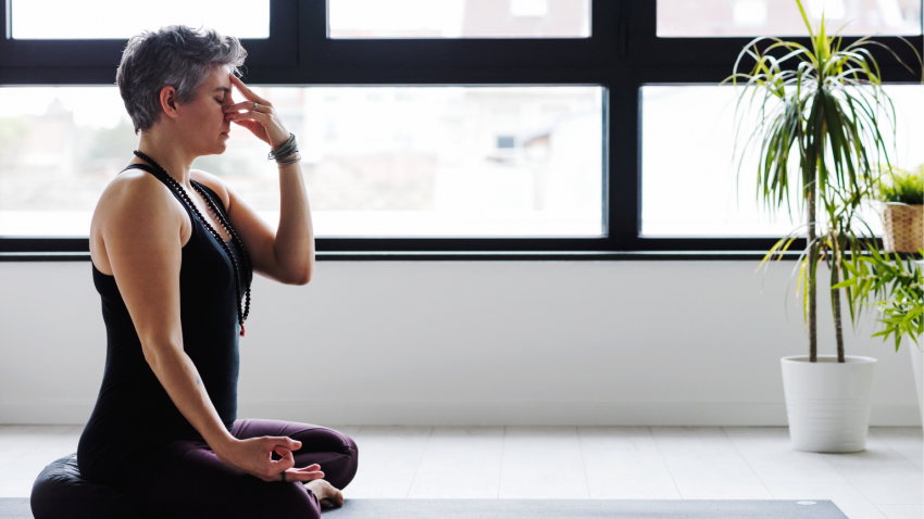 Mature woman practicing yogic breathing for better sleep