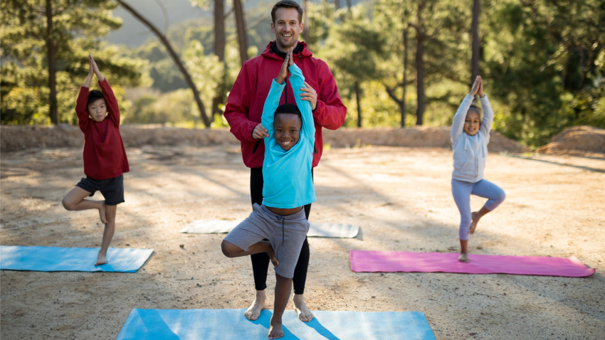 Yoga class of kids practicing Tree Pose (Vrksasana)