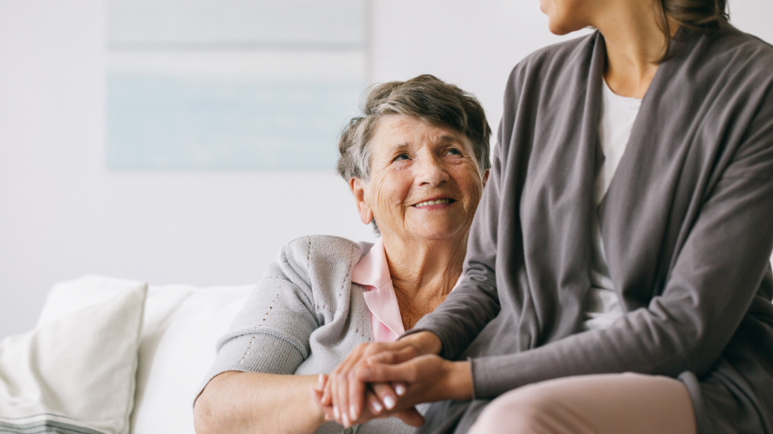 older woman with alzheimer's disease holding her daughter's hand. older woman with alzheimer's disease holding her daughter's hand.