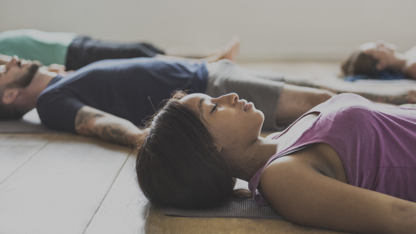 Yoga class practicing for stress relief in Corpse Pose (Savasana) Yoga class practicing for stress relief in Corpse Pose (Savasana)