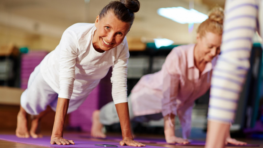 Older beginner yoga students practicing yoga for stress and the brain in Plank Pose (Phalakasana)