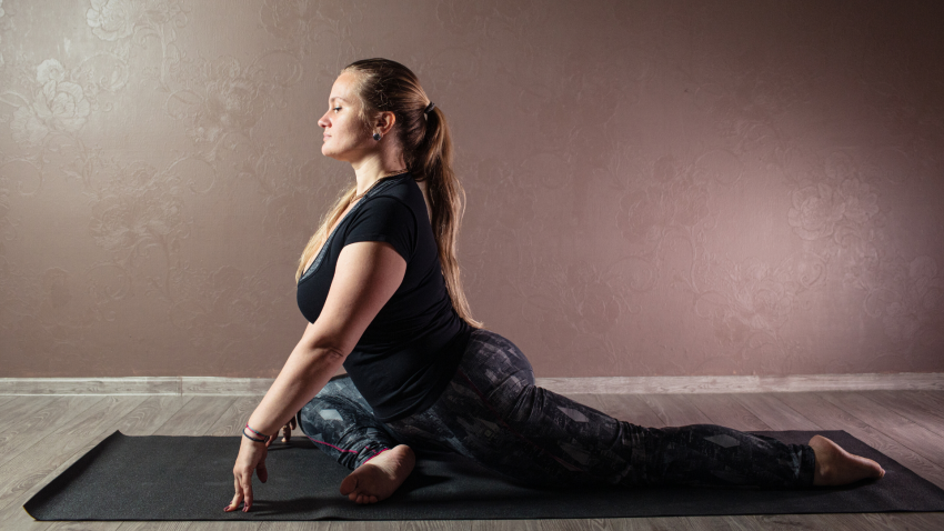 Woman practicing yoga for back pain Pigeon Pose (Kapotasana) Woman practicing yoga for back pain Pigeon Pose (Kapotasana)