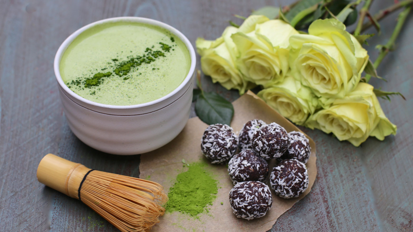 composition of a cup of matcha, healthy snacks and roses composition of a cup of matcha, healthy snacks and roses