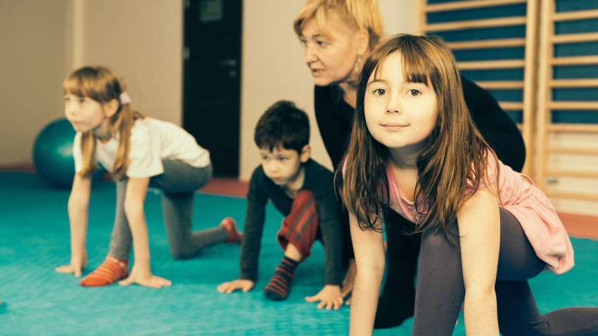 Yoga class with children doing sun salutations Yoga class with children doing sun salutations